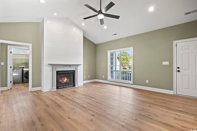 unfurnished living room featuring a large fireplace, light hardwood / wood-style floors, and high vaulted ceiling