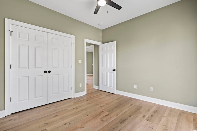 unfurnished bedroom featuring ceiling fan, a closet, and light wood-type flooring