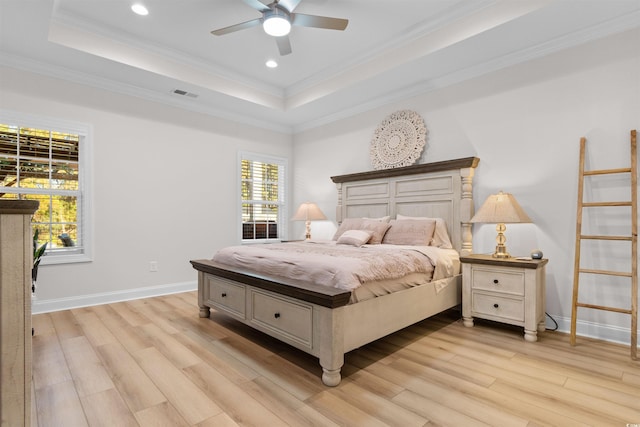 bedroom with a tray ceiling, light hardwood / wood-style flooring, ceiling fan, and ornamental molding