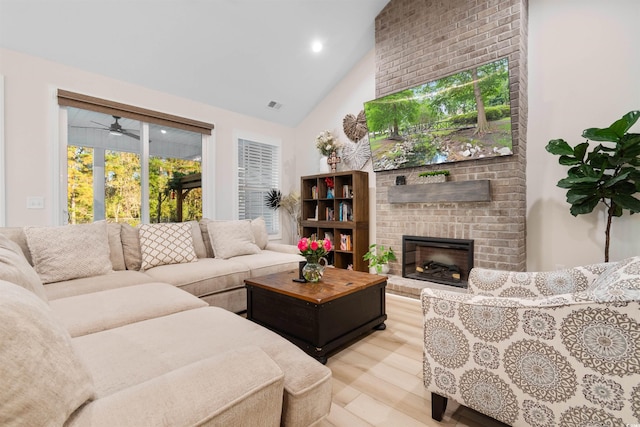 living room with ceiling fan, a healthy amount of sunlight, light hardwood / wood-style floors, and a brick fireplace