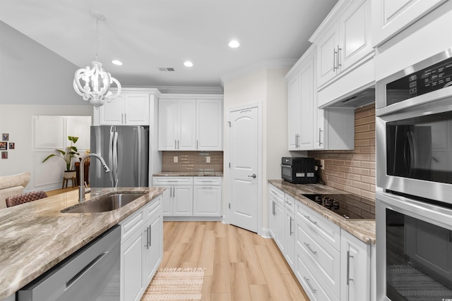 kitchen featuring white cabinets, stainless steel appliances, tasteful backsplash, and sink