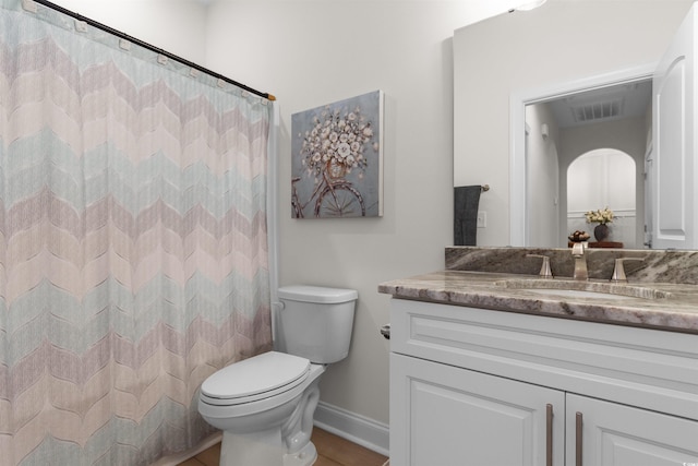 bathroom featuring a shower with curtain, vanity, and toilet