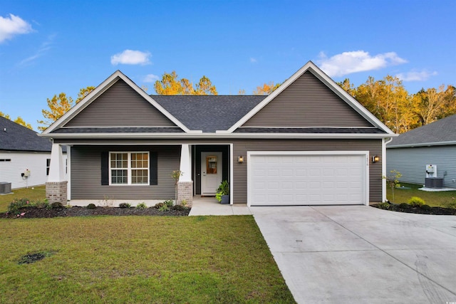 craftsman inspired home featuring a front lawn, central AC unit, and a garage