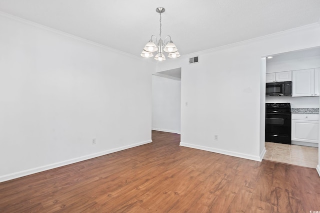 interior space featuring wood-type flooring, ornamental molding, and a notable chandelier