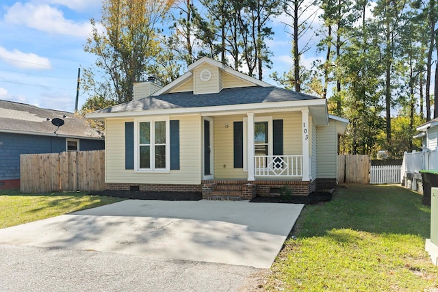 bungalow-style home featuring covered porch and a front yard