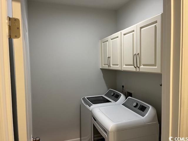 laundry area featuring washer and clothes dryer and cabinets