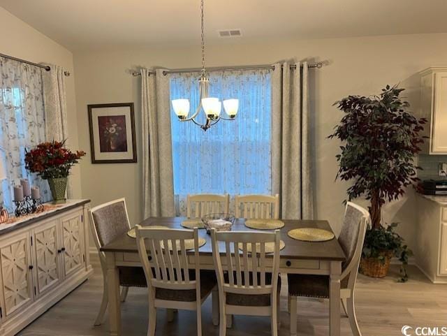 dining room featuring light hardwood / wood-style flooring and an inviting chandelier