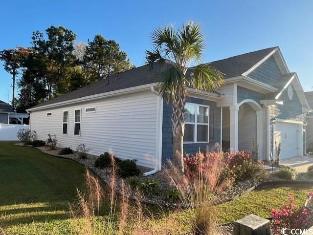 view of side of property with a yard and a garage