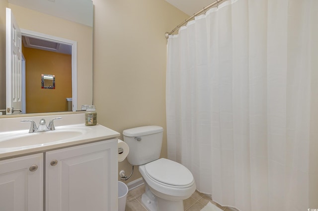 bathroom with toilet, vanity, and tile patterned floors