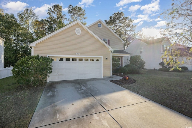 view of property featuring a garage and a front lawn