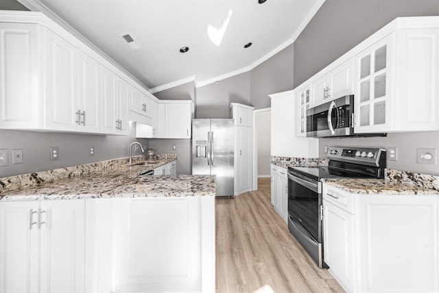 kitchen with white cabinets, stainless steel appliances, and ornamental molding