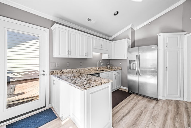 kitchen with sink, white cabinets, vaulted ceiling, and appliances with stainless steel finishes