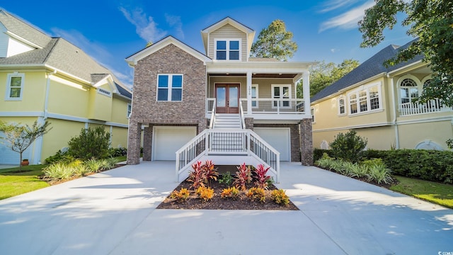 1010 Club House Dr, North Myrtle Beach, SC 29582 - view of front of property with stairway, brick siding, driveway, a garage, and covered porch