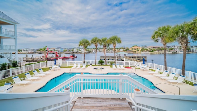 view of pool featuring a patio area, a water view, and a boat dock