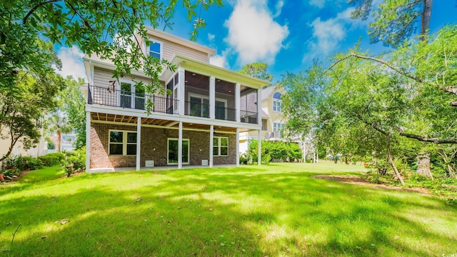 1010 Club House Dr, North Myrtle Beach, SC 29582 - rear view of property with brick siding, a sunroom, a lawn, and a patio area