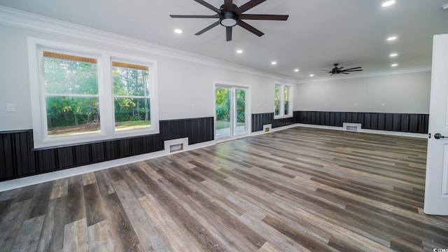 unfurnished living room with wooden walls, dark hardwood / wood-style floors, ceiling fan, and ornamental molding