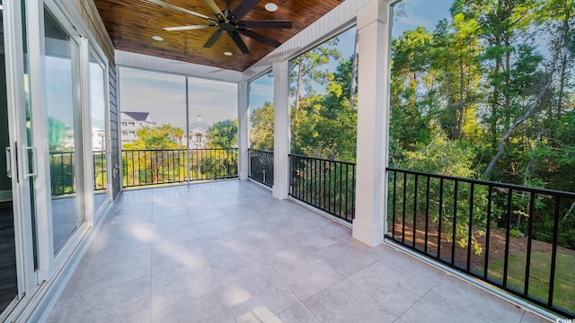 unfurnished sunroom featuring ceiling fan and wooden ceiling