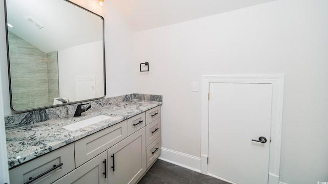 bathroom featuring tile patterned floors, vanity, and vaulted ceiling