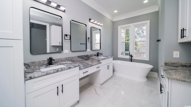 bathroom with vanity, a tub to relax in, and ornamental molding