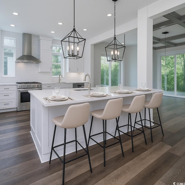 1010 Club House Dr, North Myrtle Beach, SC 29582 - kitchen with wall chimney range hood, gas range, a sink, a chandelier, and plenty of natural light