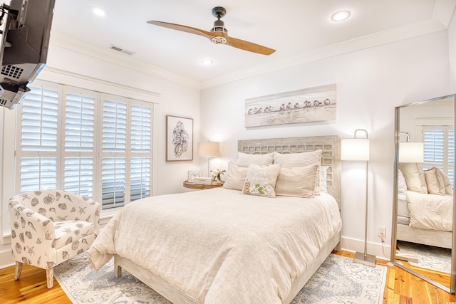 bedroom with crown molding, ceiling fan, and hardwood / wood-style flooring