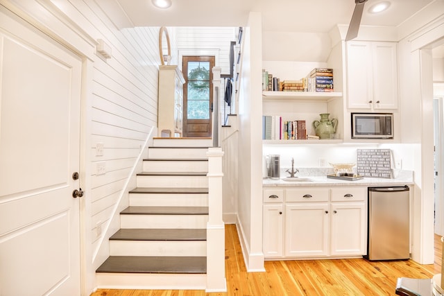 staircase with hardwood / wood-style flooring and sink