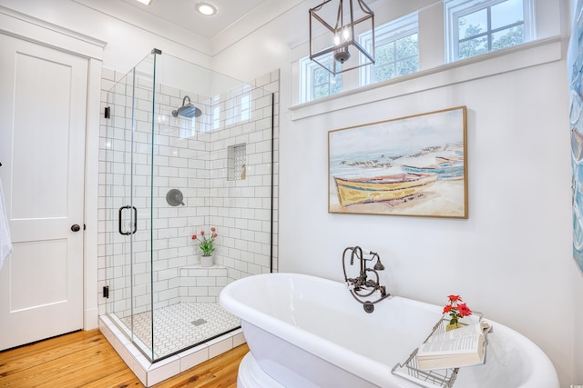 bathroom with hardwood / wood-style flooring and separate shower and tub