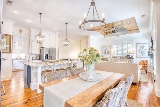 dining space with a notable chandelier, sink, and light wood-type flooring