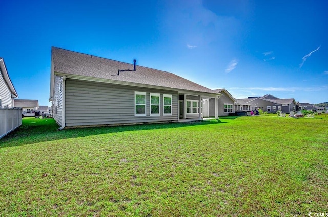 rear view of property with a lawn