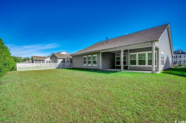 rear view of property featuring a yard