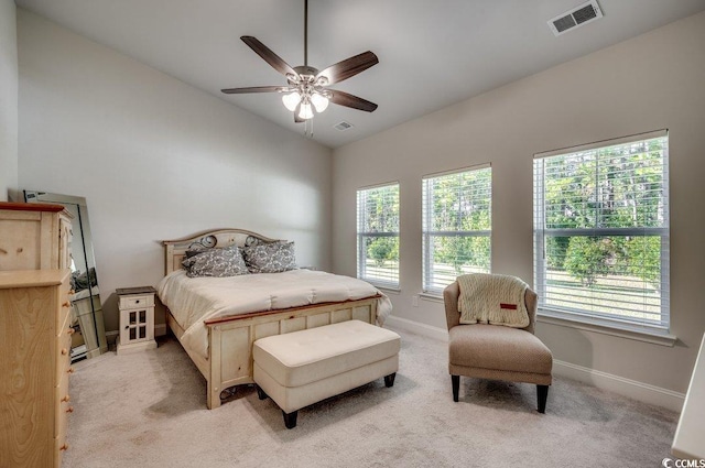 carpeted bedroom with vaulted ceiling, multiple windows, and ceiling fan