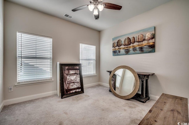 living area featuring ceiling fan and light colored carpet