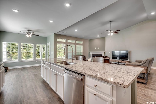 kitchen featuring dishwasher, sink, light hardwood / wood-style flooring, an island with sink, and white cabinetry