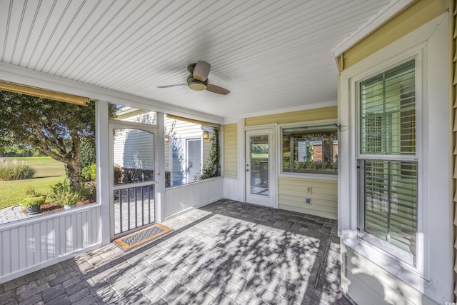 unfurnished sunroom featuring a ceiling fan