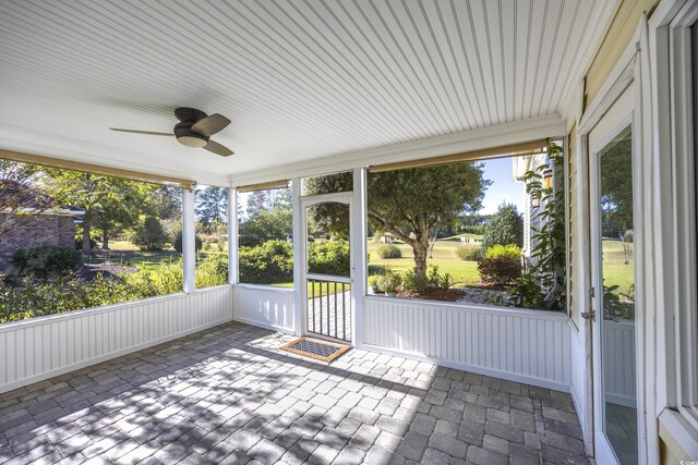 unfurnished sunroom featuring ceiling fan