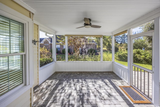 unfurnished sunroom featuring visible vents and a ceiling fan