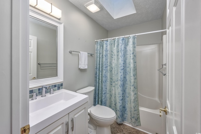 bathroom with a skylight, tasteful backsplash, vanity, shower / bath combination with curtain, and a textured ceiling