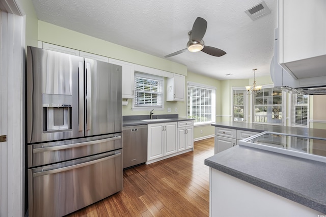 kitchen with white cabinetry, visible vents, appliances with stainless steel finishes, and dark wood-style flooring