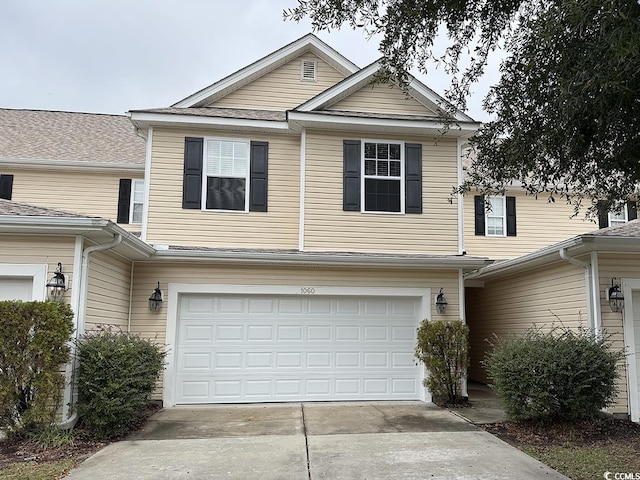 multi unit property featuring concrete driveway and an attached garage