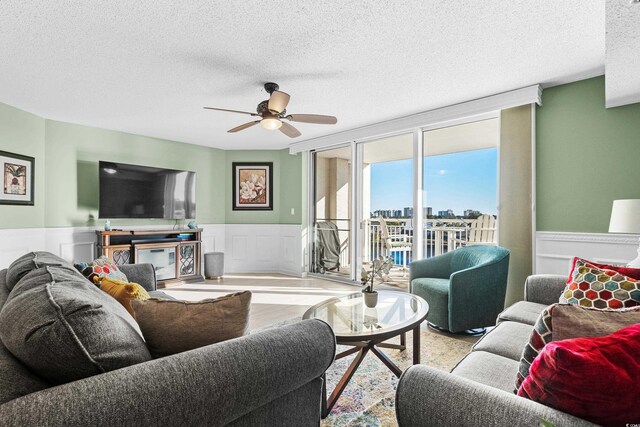 2151 Bridge View Ct Unit 2502, North Myrtle Beach, SC 29582 - living area with a textured ceiling, a ceiling fan, and a wainscoted wall