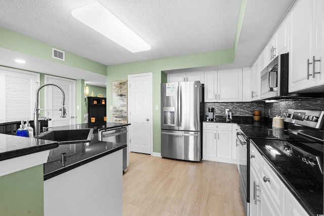 2151 Bridge View Ct Unit 2502, North Myrtle Beach, SC 29582 - kitchen with appliances with stainless steel finishes, a sink, white cabinetry, and a textured ceiling