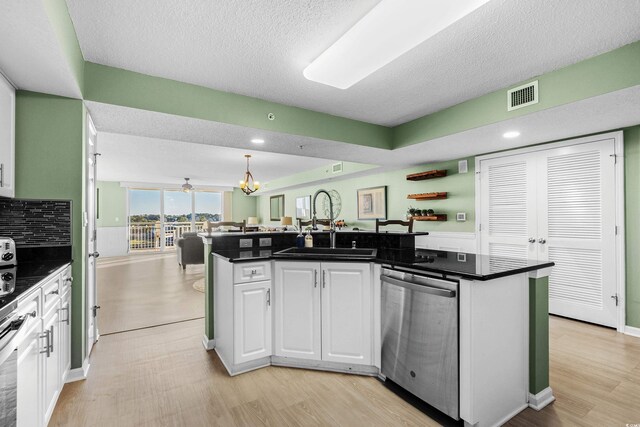 2151 Bridge View Ct Unit 2502, North Myrtle Beach, SC 29582 - kitchen with stainless steel dishwasher, a sink, white cabinets, open floor plan, and a textured ceiling