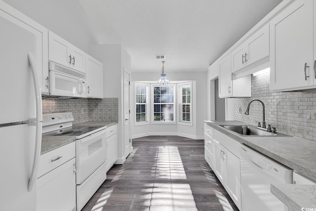 kitchen featuring white cabinets, white appliances, hanging light fixtures, and sink