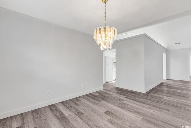 unfurnished dining area featuring light hardwood / wood-style floors, vaulted ceiling, and a chandelier