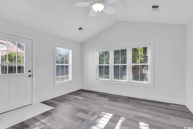 interior space featuring ceiling fan, light wood-type flooring, and lofted ceiling