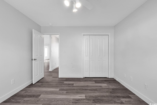 unfurnished bedroom with dark hardwood / wood-style flooring, a closet, and ceiling fan