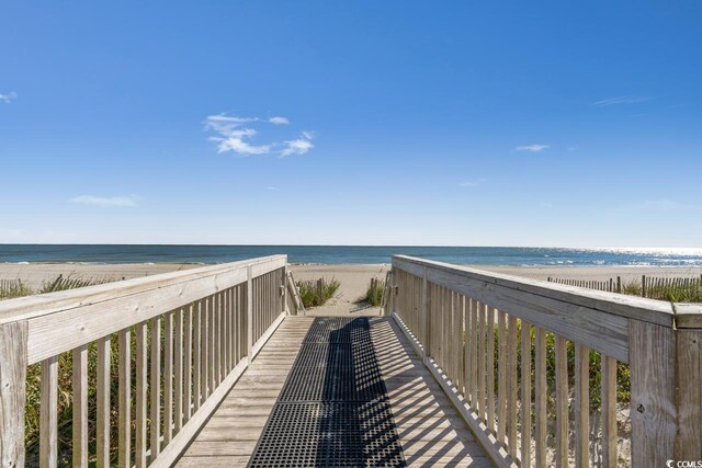 view of community with a water view and a beach view