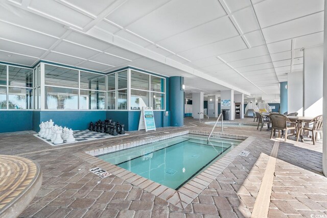 view of pool featuring a patio area and an indoor hot tub