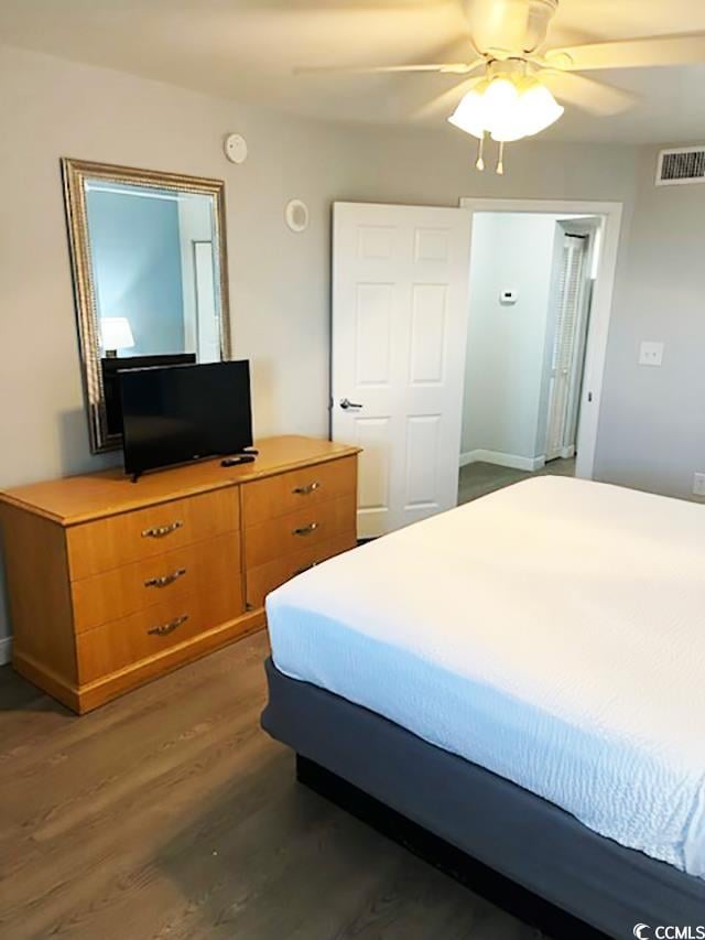 bedroom with dark hardwood / wood-style floors and ceiling fan