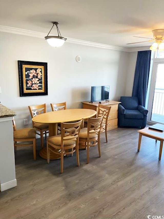 dining room with ceiling fan, wood-type flooring, and ornamental molding